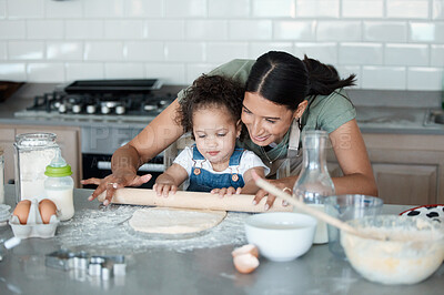 Buy stock photo Shot of a young mom baking with her toddler at home