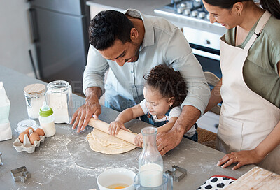 Buy stock photo Shot of a couple baking with their toddler at home