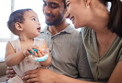 Buy stock photo Shot of a young couple bonding with their baby girl on a sofa at home