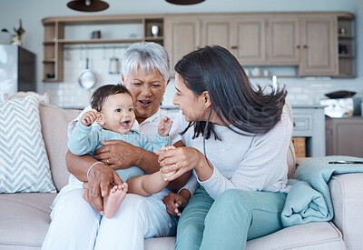 Buy stock photo Shot of a mature woman bonding with her granddaughter and daughter on the sofa at home