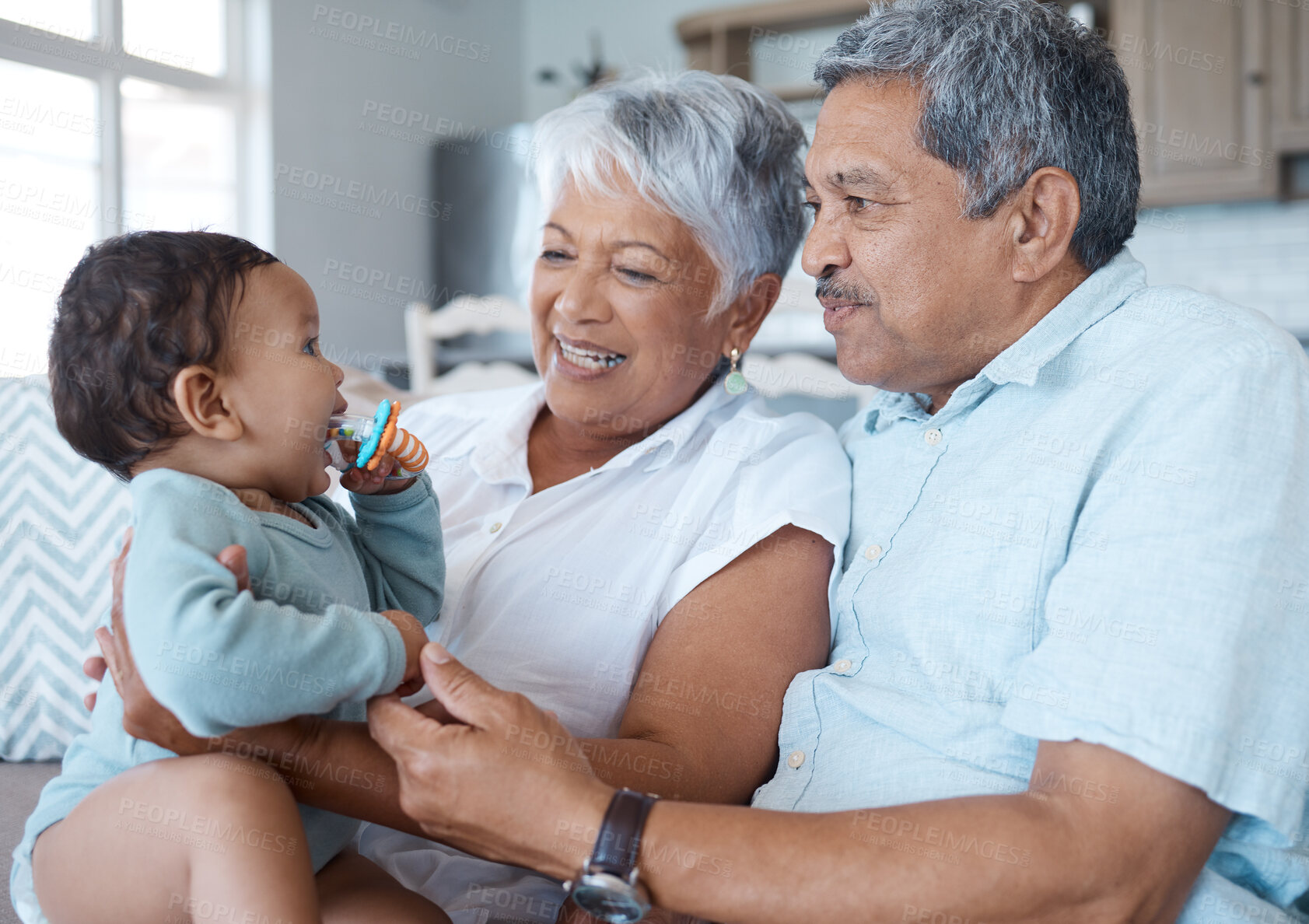 Buy stock photo Shot of grandparents bonding with their grandchild on a sofa at home