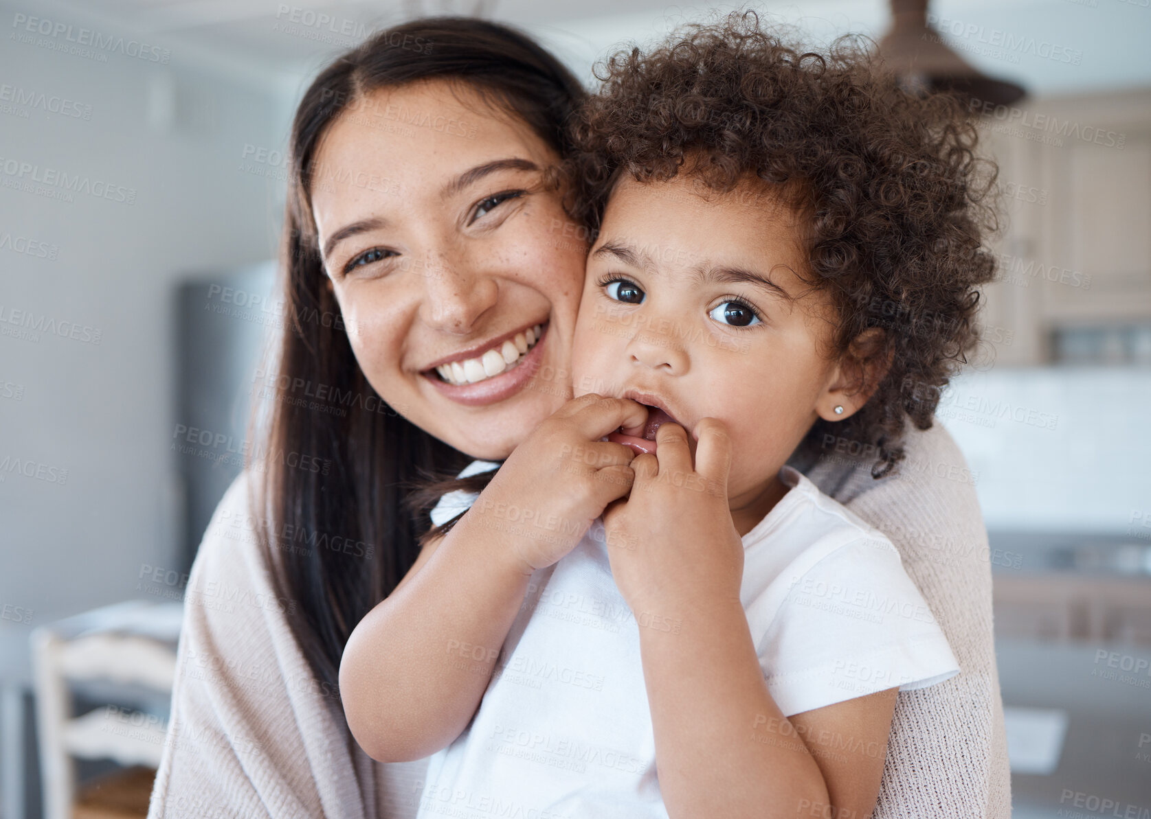 Buy stock photo Shot of a young mother holding her daughter at home