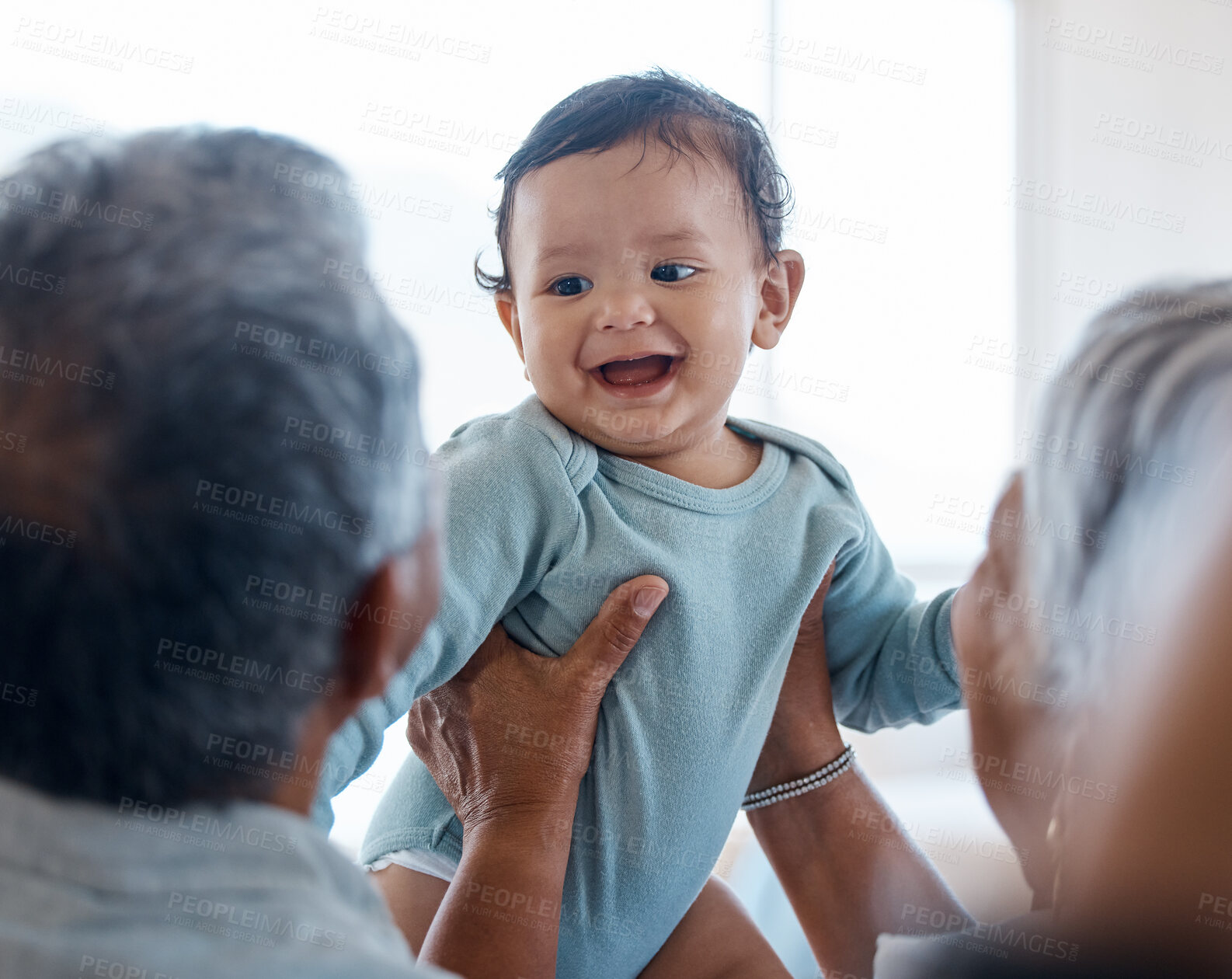 Buy stock photo Relax, bonding and grandparents with baby on sofa for smile, laughing and support. Love, happiness and generations with senior man and woman holding child in living room of family home together