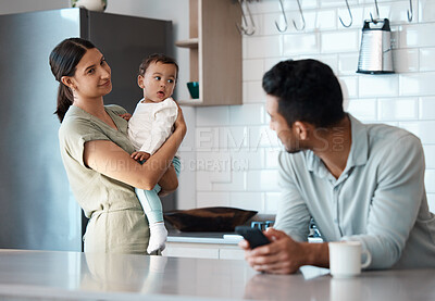 Buy stock photo Shot of a young man ignoring his wife and child while using his phone at home
