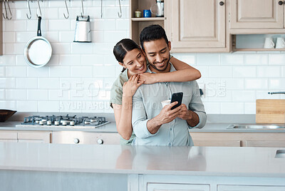 Buy stock photo Shot of a young couple using a phone together at home