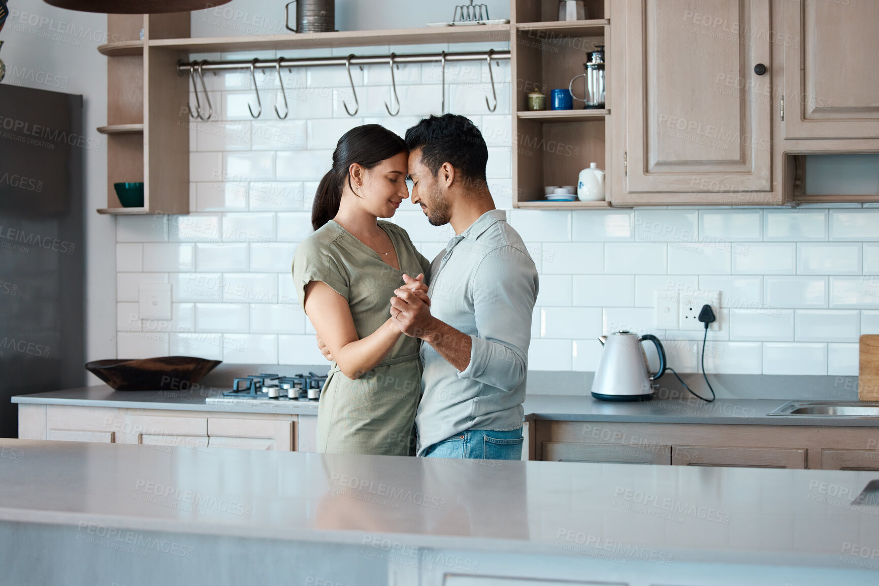 Buy stock photo Shot of a young couple dancing in the kitchen at home