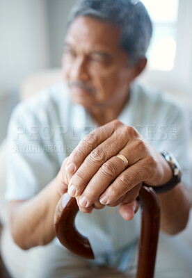 Buy stock photo Closeup shot of a senior man holding his cane while sitting in the old age home