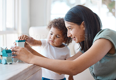 Buy stock photo Shot of a young mother and daughter playing with a toy at home