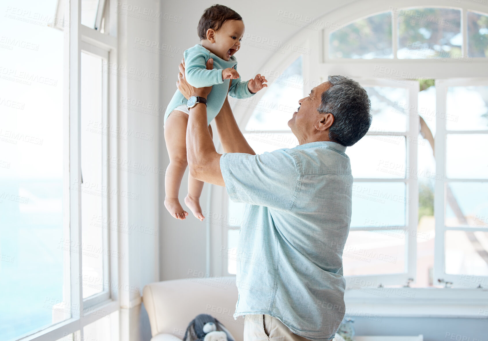 Buy stock photo Shot of a senior man spending time with his grandchild at home