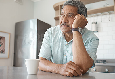 Buy stock photo Shot of a senior man looking pensive while drinking coffee at home