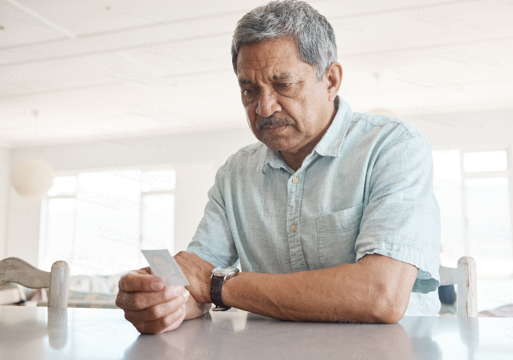 Buy stock photo Thinking, photograph and sad with old man in kitchen for memory, reflection and nostalgia. Morning, remember and lonely with senior person and picture at home for emotional, history and vintage