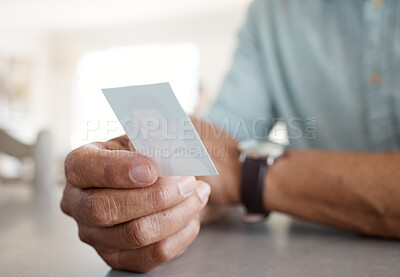 Buy stock photo Shot of an unrecognizable person holding a photo at home