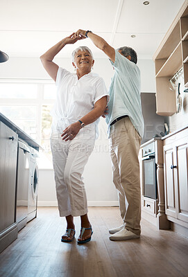 Buy stock photo Shot of a senior couple dancing in the kitchen at home