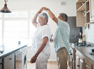 Buy stock photo Shot of a senior couple dancing in the kitchen at home