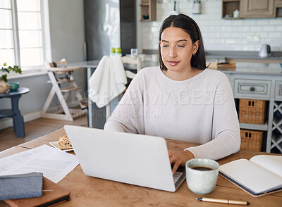 Buy stock photo Shot of a young woman working on a laptop while sitting at home