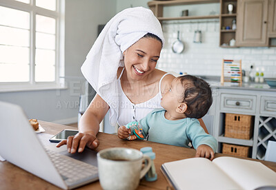 Buy stock photo Shot of a mom working on her laptop with her baby on her lap