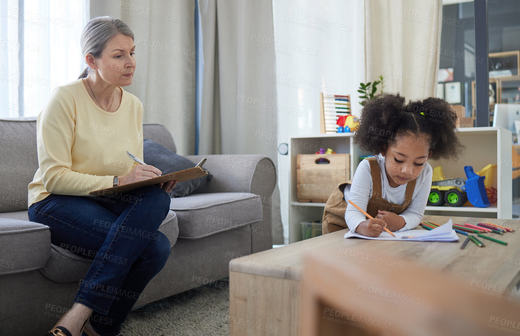 Buy stock photo Shot of a little girl drawing in a psychologists office