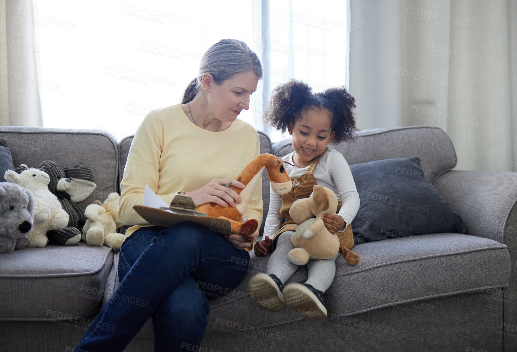 Buy stock photo Shot of a mature therapist encouraging her young patient to play with toys