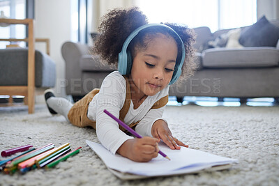 Buy stock photo Shot of a little girl drawing while listening to music at a psychologists office