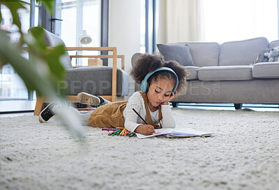Buy stock photo Shot of a little girl drawing while listening to music at a psychologists office