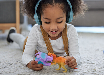 Buy stock photo Shot of a little girl playing with toys while listening to music in a physiologists office