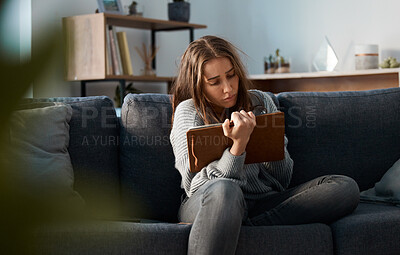 Buy stock photo Shot of an anxious young woman writing in her journal