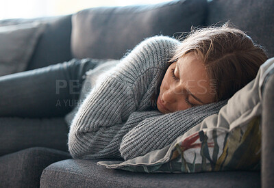 Buy stock photo Shot of a young woman lying on her couch feeling depressed