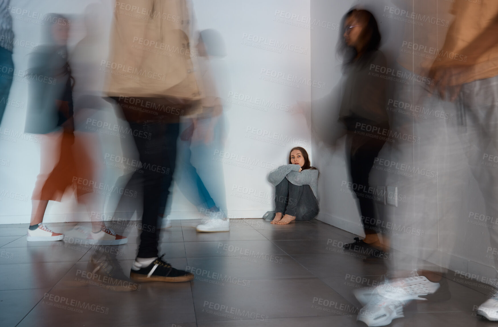 Buy stock photo Shot of a young woman sitting on the floor with people around her