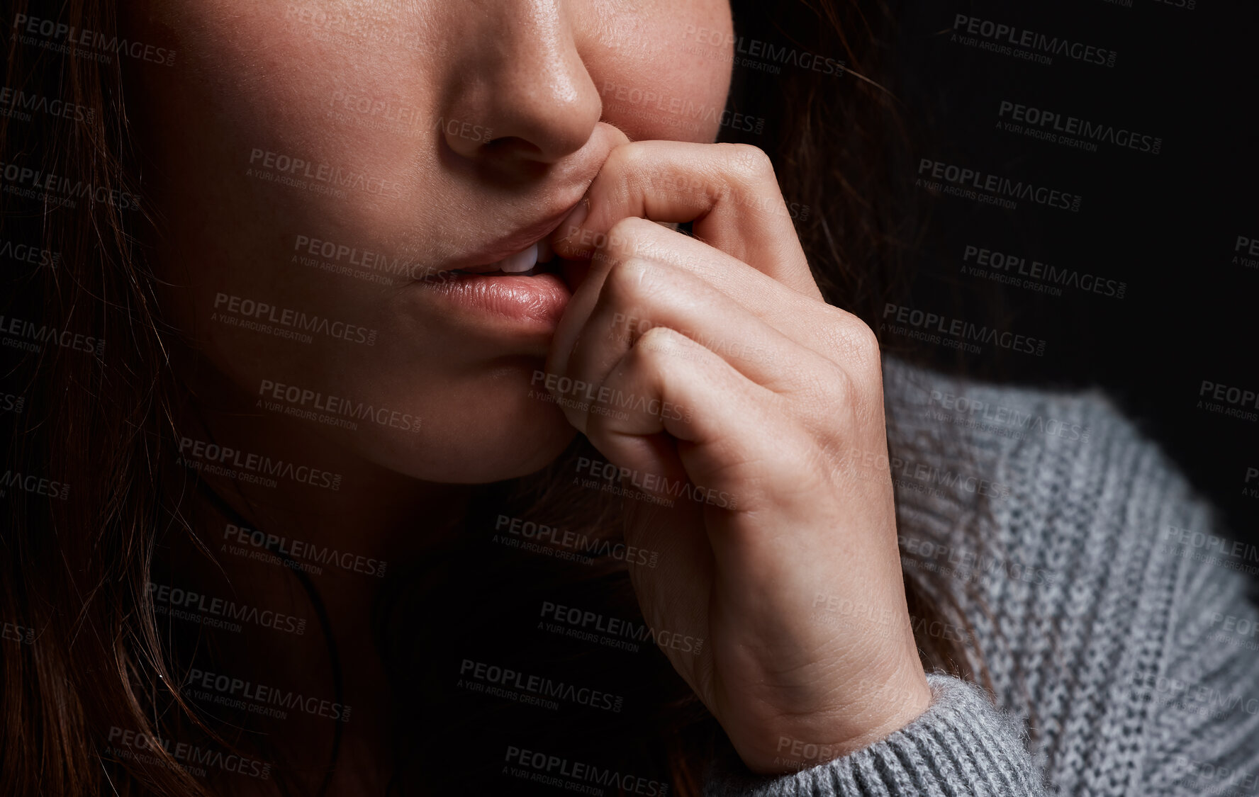 Buy stock photo Stress, hands and person biting nails in fear for domestic violence, trauma and terror in dark studio. Gender abuse, nervous or scared victim with depression, danger or anxiety on black background