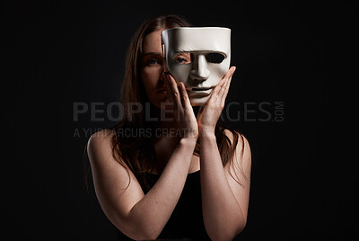 Buy stock photo Studio shot of a woman hiding behind a blank mask
