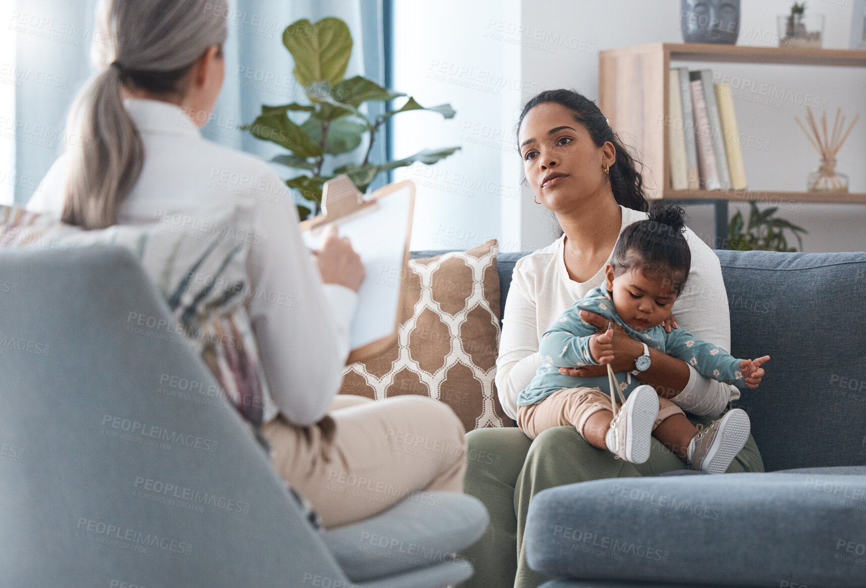 Buy stock photo Shot of an attractive young woman sitting with her daughter during a consultation with a psychologist