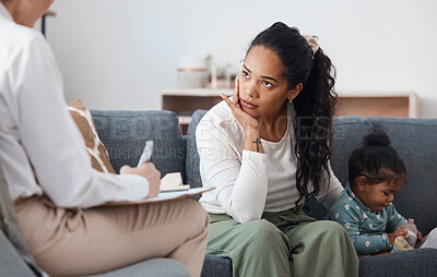 Buy stock photo Shot of an attractive young woman sitting with her daughter during a consultation with a psychologist