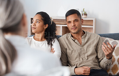 Buy stock photo Shot of a young couple sitting together and looking annoyed during a consultation with a psychologist