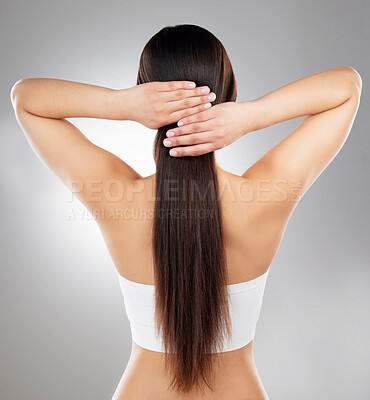 Buy stock photo Rearview studio shot of an unrecognizable woman with beautiful silky hair posing against a grey background