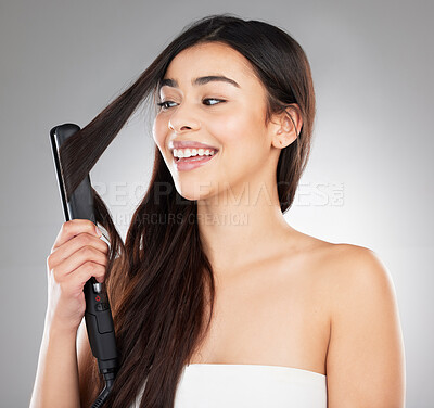 Buy stock photo Studio shot of a beautiful young woman styling her hair against a grey background