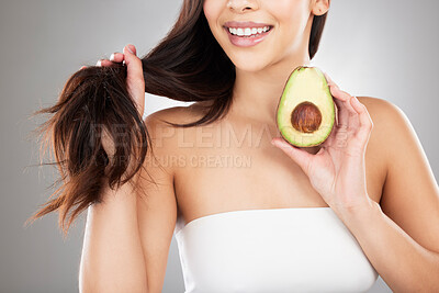 Buy stock photo Hair care, beauty and woman with an avocado in a studio for a natural, organic or cosmetic mask. Self care, grooming and closeup of a female model with a fruit for a hair treatment by gray background