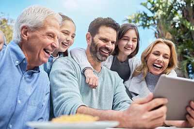 Buy stock photo Shot of a family using a tablet outside