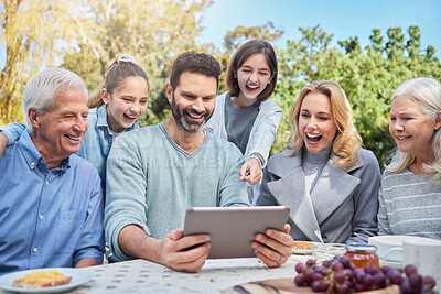 Buy stock photo Shot of a family using a tablet outside