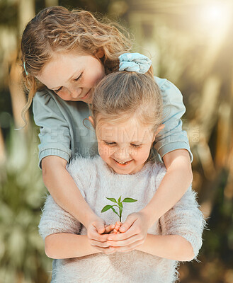 Buy stock photo Shot of sisters holding a plant outside