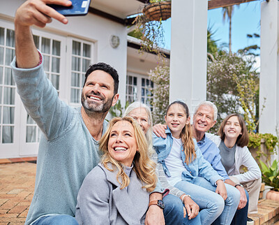 Buy stock photo Shot of a family sitting outside together and bonding while taking selfies on a cellphone