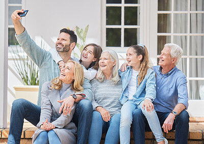 Buy stock photo Shot of a family sitting outside together and bonding while taking selfies on a cellphone