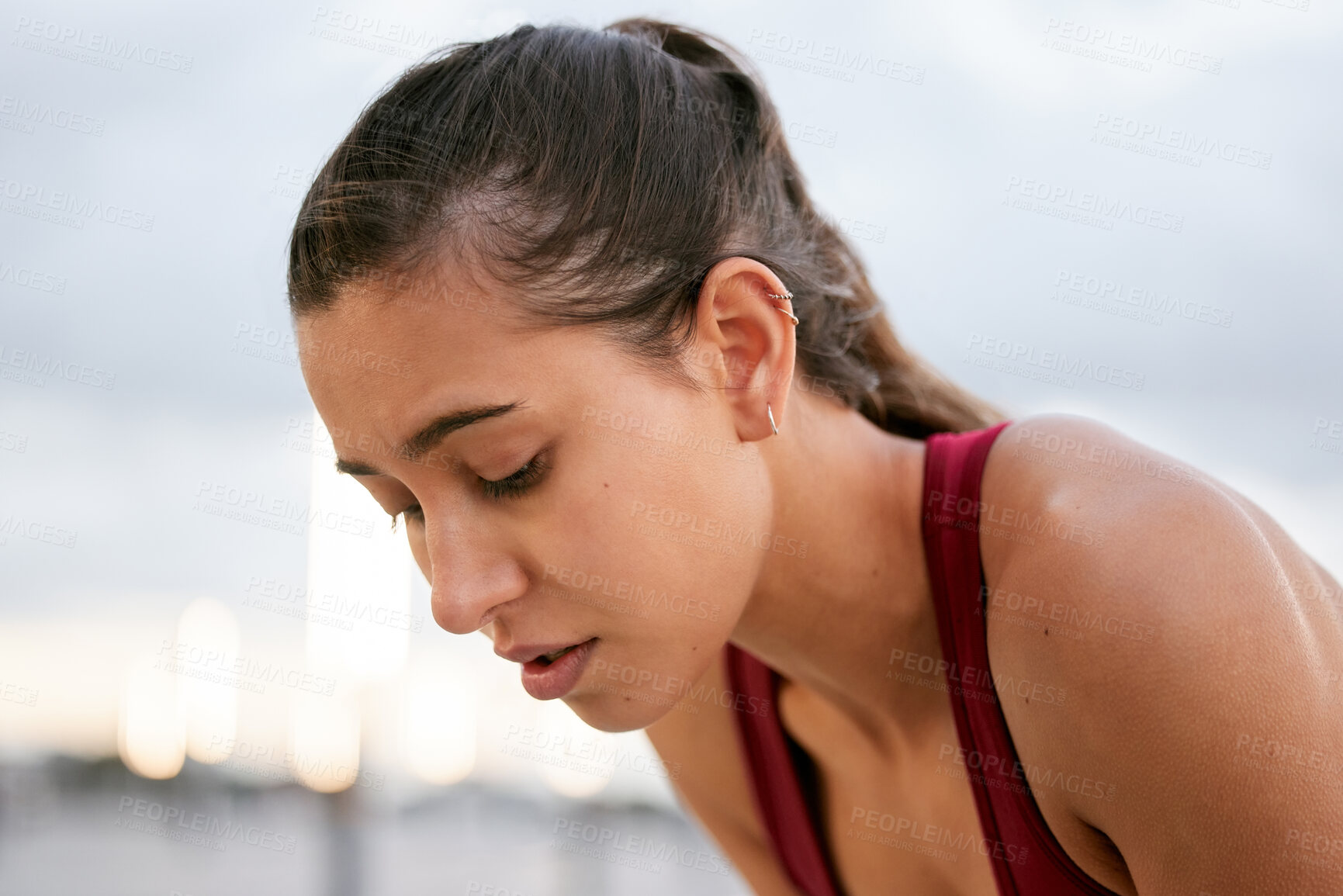 Buy stock photo Shot of a young woman taking a break while on a run outside