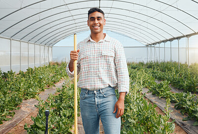 Buy stock photo Portrait of a young man using a gardening tool while working in a greenhouse on a farm