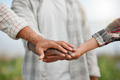 Buy stock photo Closeup shot of a group of unrecognisable people joining their hands together in a huddle while working together on a farm