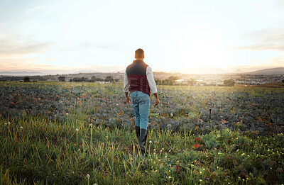 Buy stock photo Shot of a farmer standing on a field