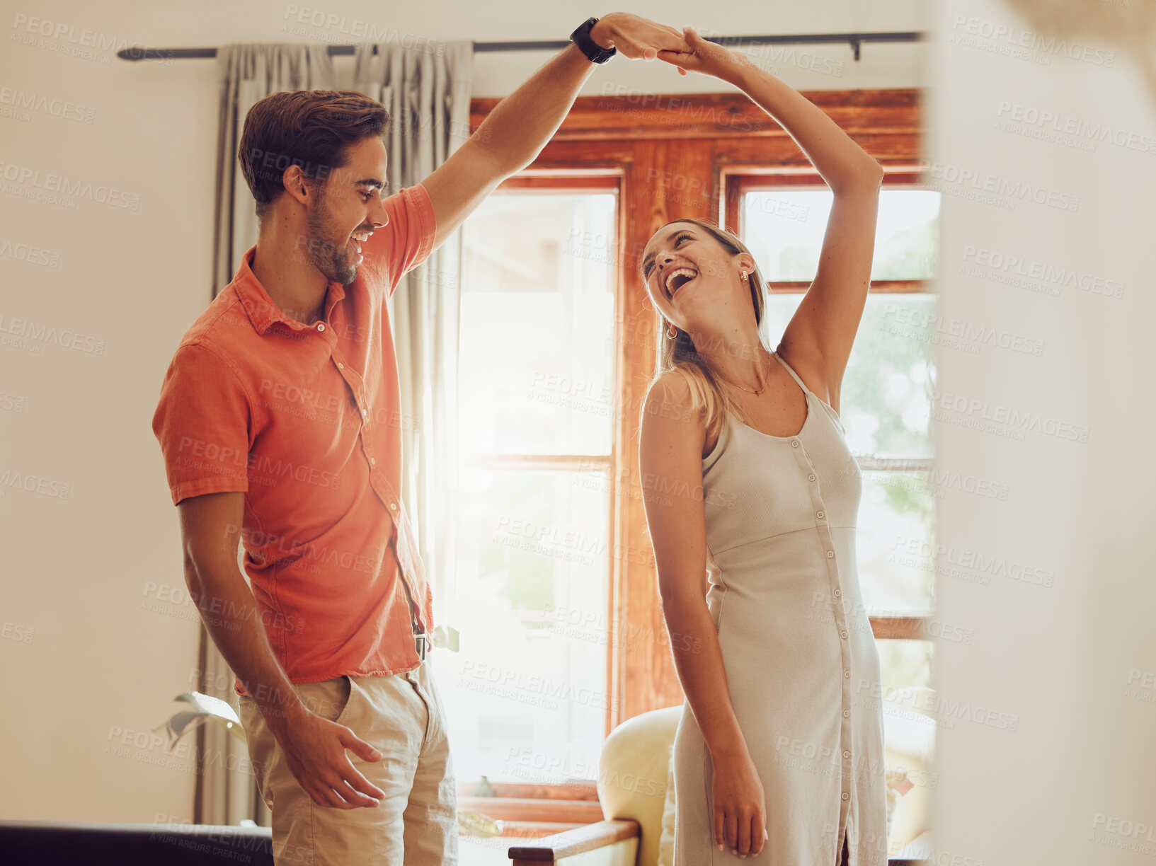 Buy stock photo Shot of a young couple dancing together at home