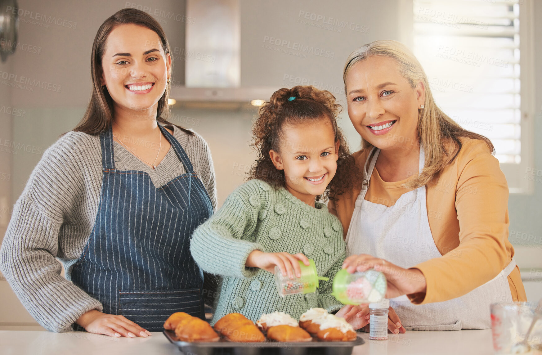 Buy stock photo Portrait, happy mother and grandmother with child baking or girl learning with family in home kitchen. Face, mom and kid with generations for cooking cupcake, food or help sprinkle rainbow on dessert