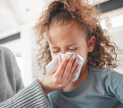 Buy stock photo Shot of a little sick girl blowing her nose at home