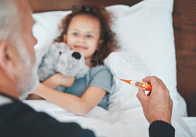 Buy stock photo Shot of a doctor checking a sick little girl's temperature at home