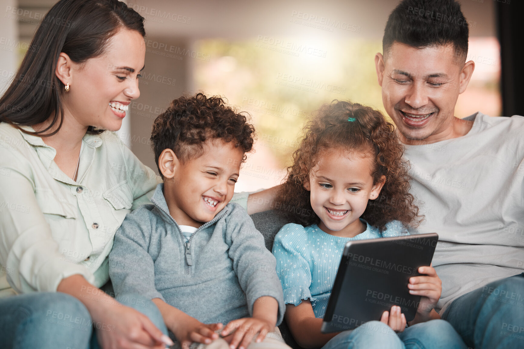 Buy stock photo Shot of a young family using a digital tablet together at home